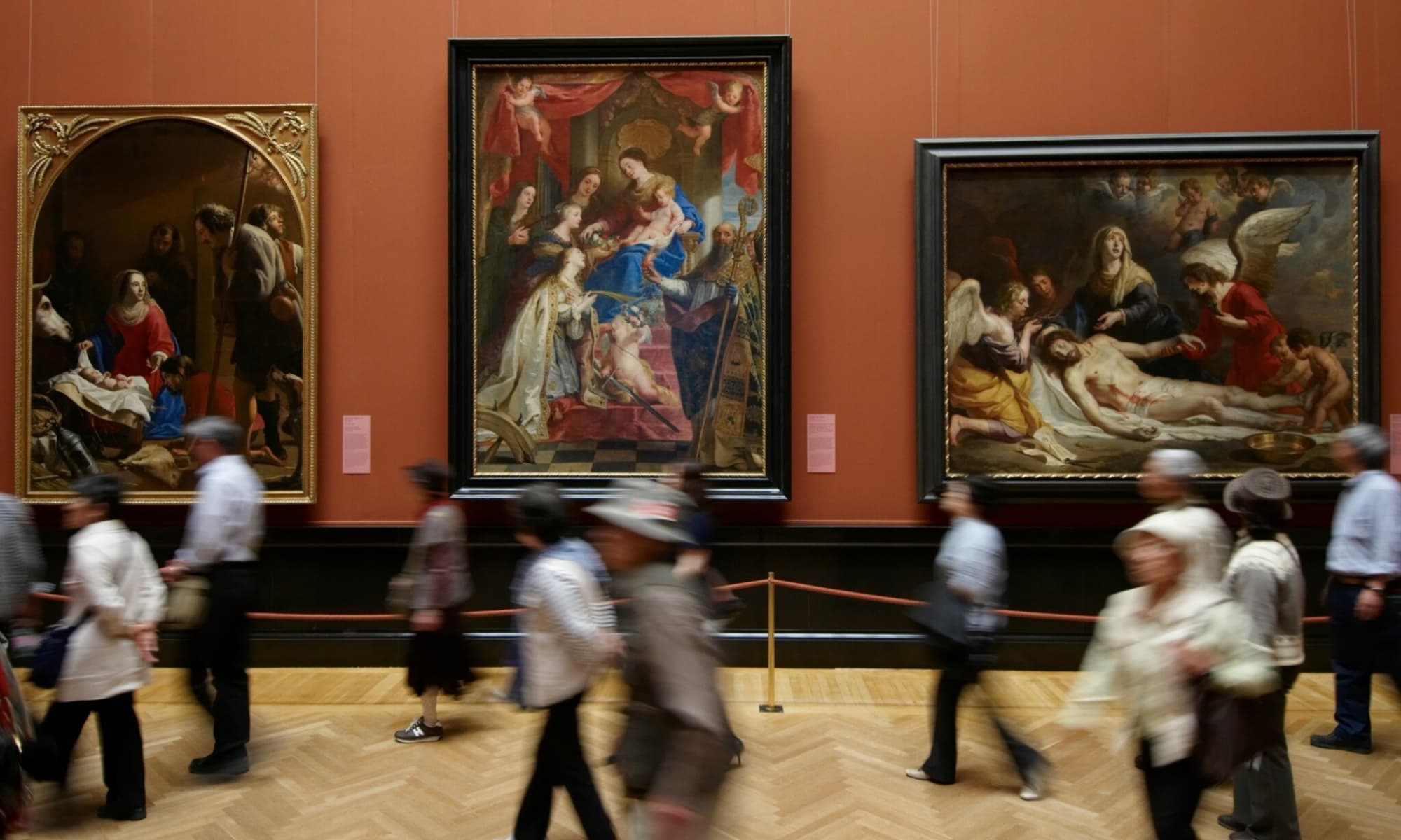 Ansicht eines Ausstellungssaals im Kunsthistorischen Museum Wien. Das Bild ist mit langer Belichtungszeit aufgenommen, sodass die sich vorbeibewegenden Menschen verschwimmen.