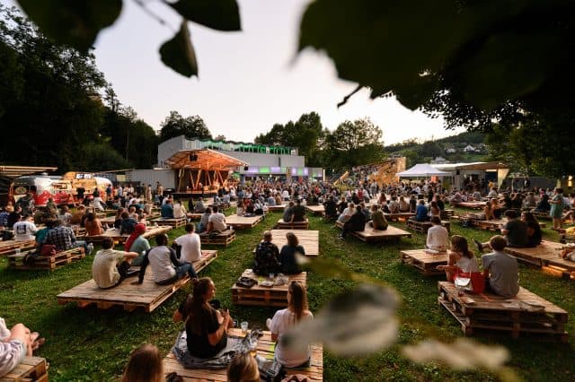 Festival in Österreich im Grünen, Menschen vor einer Bühne im Grünen