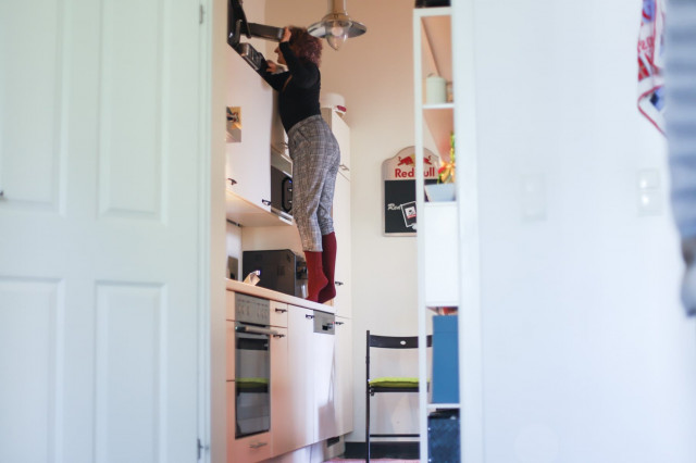 Ein Foto einer kleinen Frau, die versucht, etwas zu montieren