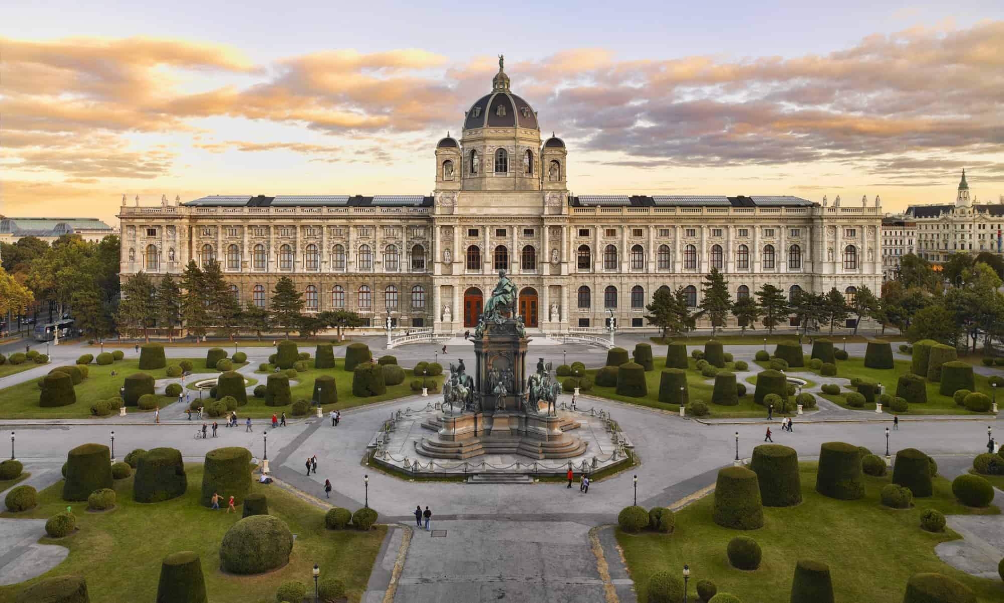 Ein Bild vom Kunsthistorischen Museum in Wien, davor ist der Vorplatz zwischen den Museen zu erkennen, dahinter der Sonnenuntergang