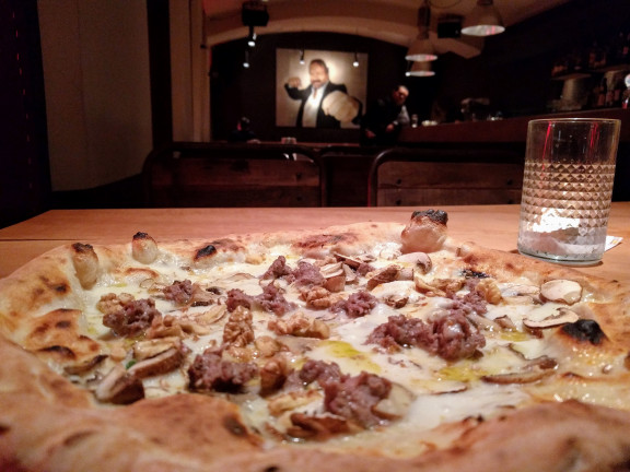 Pizza Randale Wien: Eine Pizza und Bud Spencer im Hintergrund