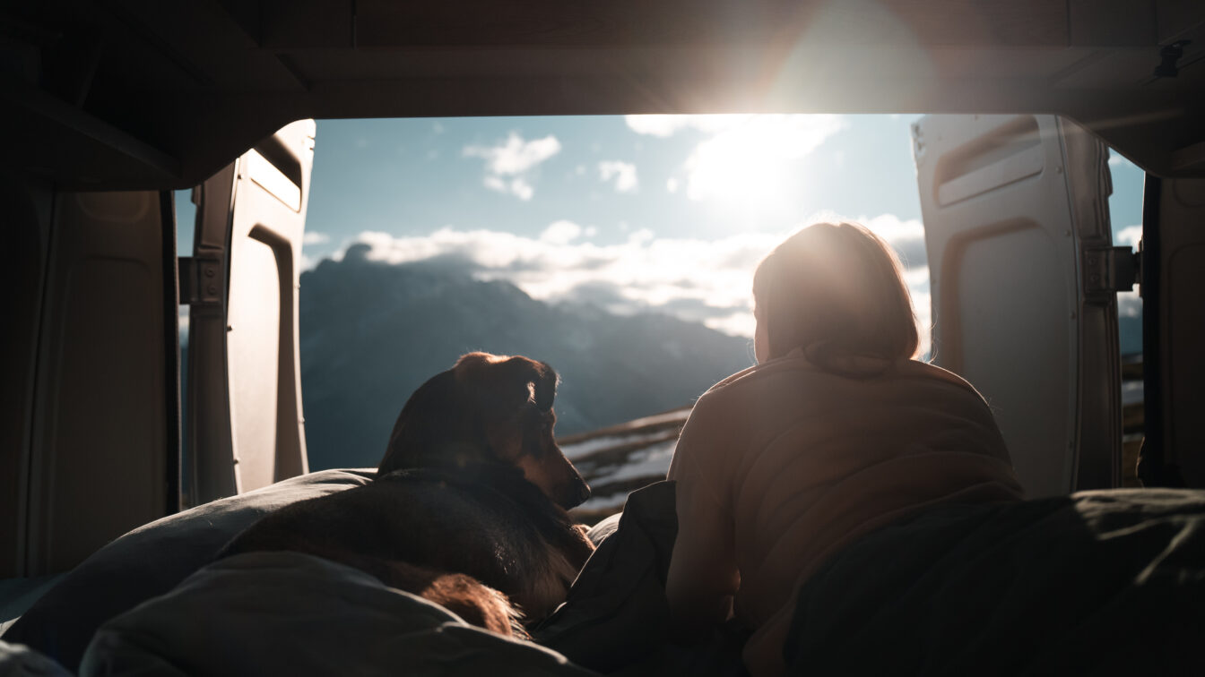 Blick aus dem Camper mit Hund und Frau