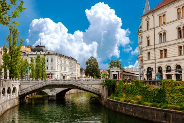Stadtansicht von Ljubljana, Gebäude neben einem Fluss, große weiße Wolke