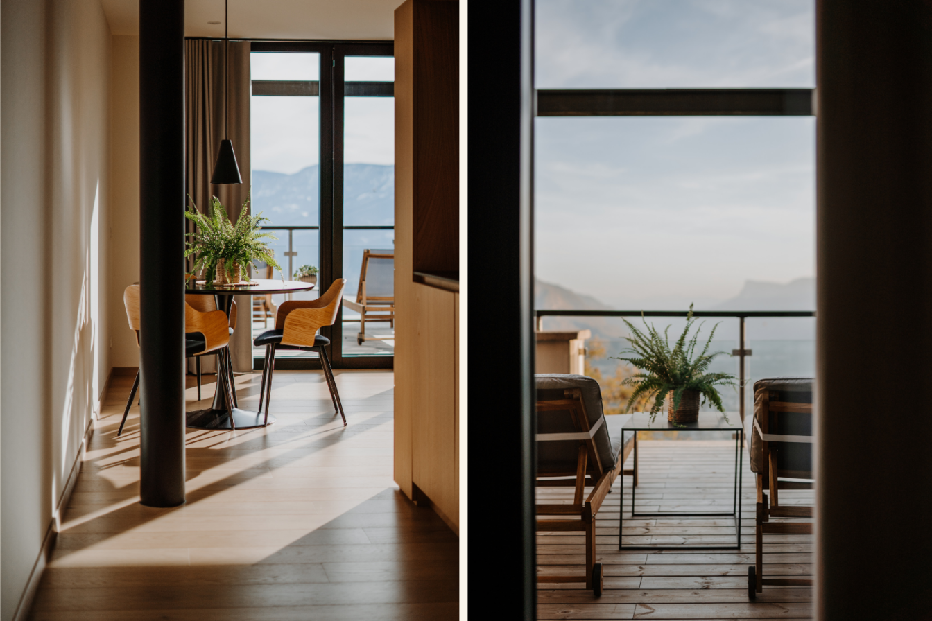 Man sieht das Innenleben des Hotels Farnhaus in Südtirol. Es ist modern und mit viel Holz und Glasflächen gestaltet. Durch die Fenster bekommt man einen schönen Blick aufs Tal und die Berge 