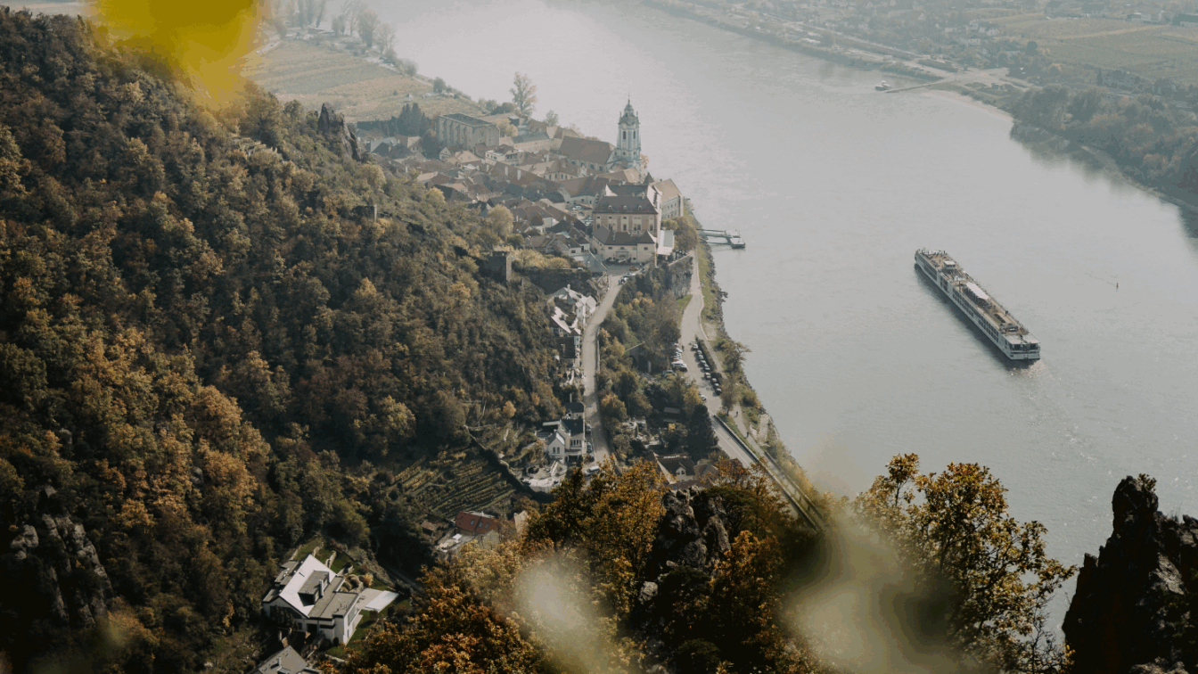 Ein Ausschnitt der Donau mit einem Schiff, das durch die Wachau unterwegs ist. Daneben: eine herbstliche Landschaft in der Wachau