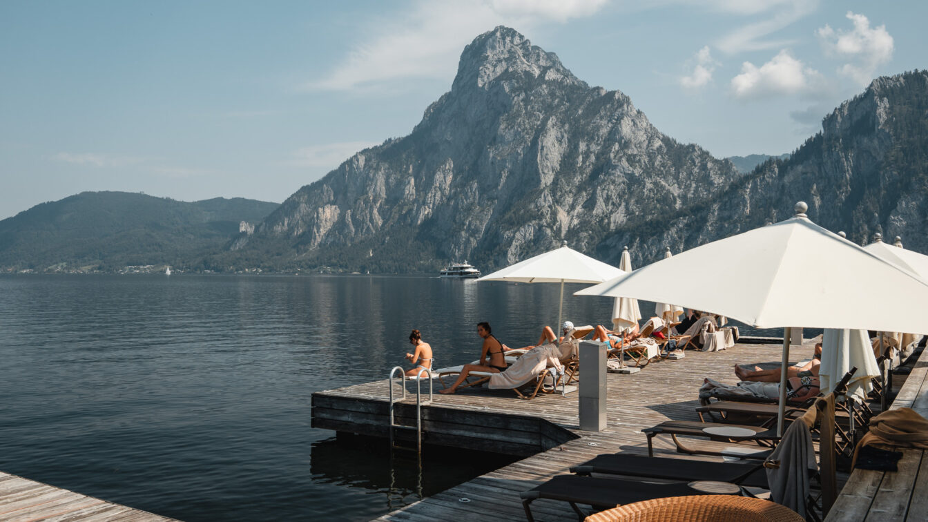 Ob bei einer Schifffahrt oder beim Radfahren, der Traunsee ist atemberaubend. Hier der Blick von der Terrasse am Bootshaus Traunsee.