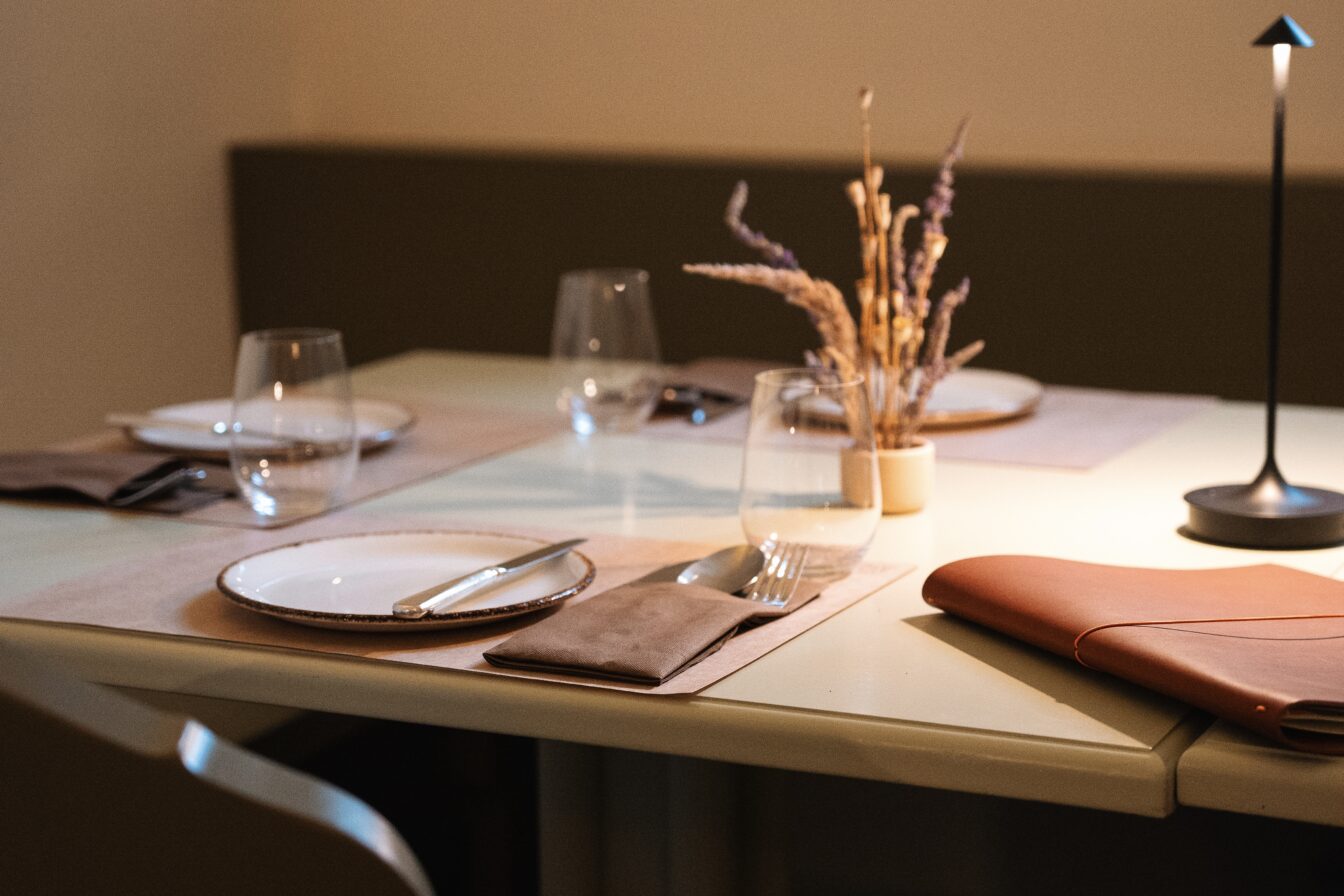 Gemütlicher Restaurantbereich im Kirchenwirt Rust mit mittelalterlichem Mauerwerk und elegant gedecktem Tisch – stilvolles Ambiente im Burgenland