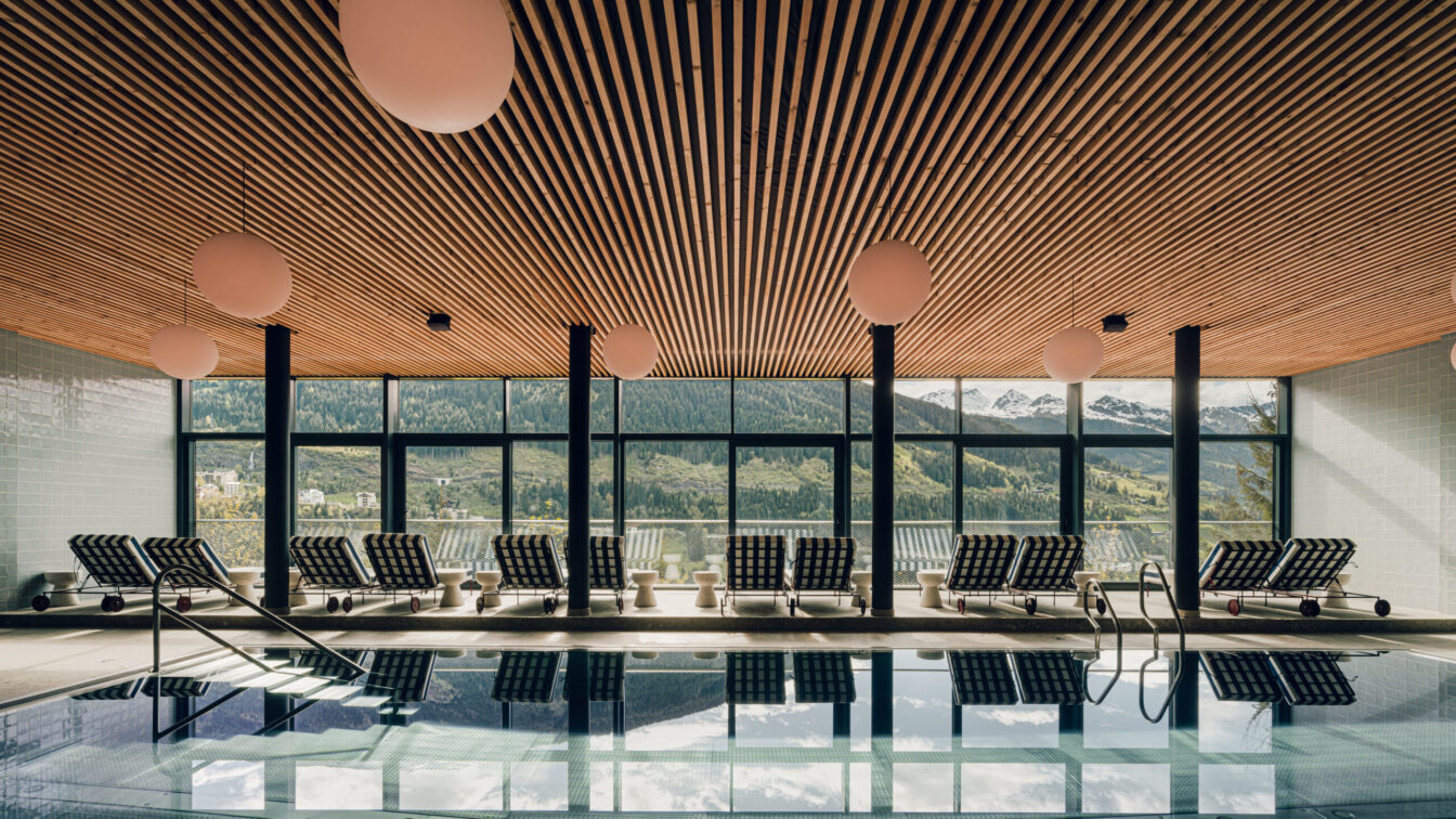 Modernes Designhotel the comodo mit stilvollem Wellnessbereich und elegantem Zimmer – lichtdurchflutetes Hallenbad mit Liegen und Designerleuchten sowie gemütliches Schlafzimmer mit hochwertiger Einrichtung und skandinavischem Flair.