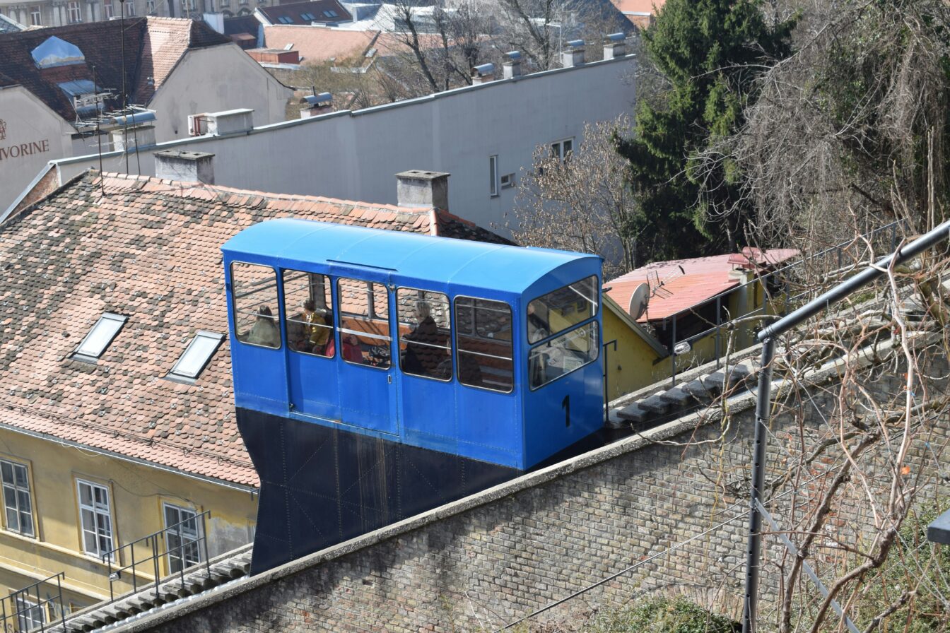 Eine blaue Bahn, die einen steilen hand in Zagreb hinauffährt.