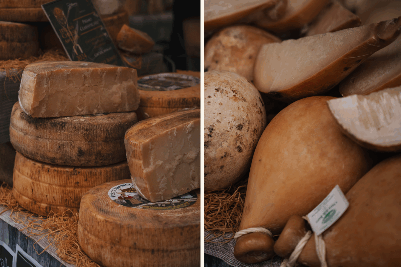 Vielfalt an italienischem Käse auf dem Mercato in Triest – links gereifter Pecorino in ganzen Laiben und Stücken, rechts geräucherter Provola und andere traditionelle Hartkäsesorten