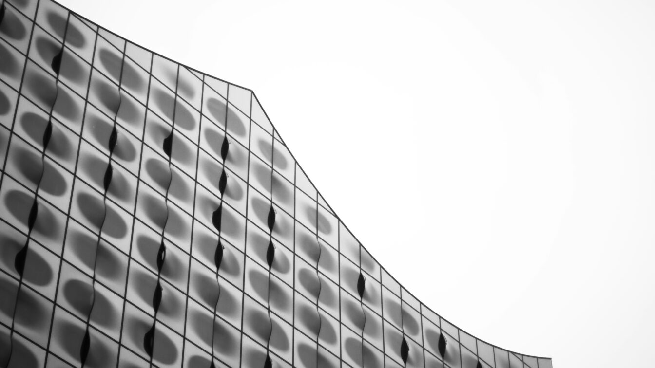 Fassadenansicht der Elbphilharmonie in Hamburg mit wellenförmiger Glasarchitektur, die Regentropfen und Reflexionen aufnimmt – modernes Wahrzeichen im Hamburger Regenwetter.