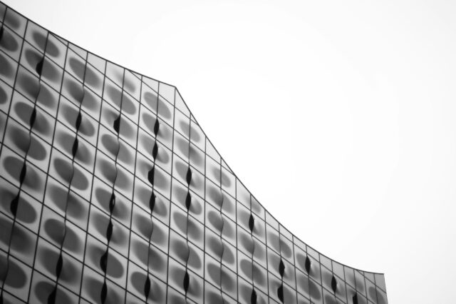 Fassadenansicht der Elbphilharmonie in Hamburg mit wellenförmiger Glasarchitektur, die Regentropfen und Reflexionen aufnimmt – modernes Wahrzeichen im Hamburger Regenwetter.