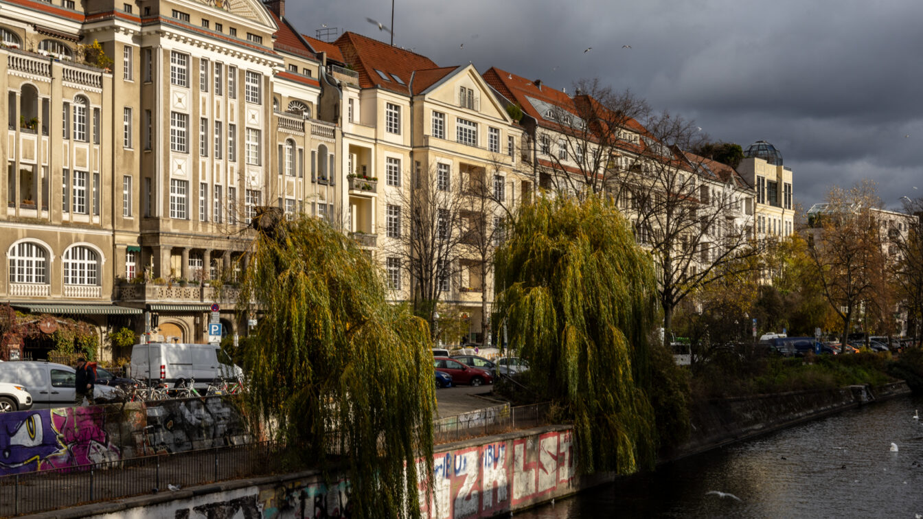Uferpromenade am Landwehrkanal in Berlin-Kreuzberg mit historischen Altbauten, Weidenbäumen und Graffiti – beliebte Fotolocation und Spazierweg im Kreuzberg Guide.