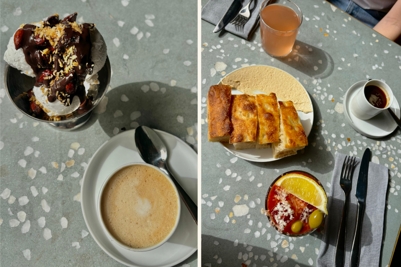 Das Bild zeigt ein stilvolles Frühstück bei Estelle Dining in Prenzlauer Berg, Berlin. Links eine Schale mit veganem Joghurt oder Eis, garniert mit Schokolade, Nüssen und Kokos, dazu Cappuccino. Rechts Fladenbrot mit Hummus, ein Cocktail mit Orange und Oliven sowie Espresso auf einem Terrazzo-Tisch.