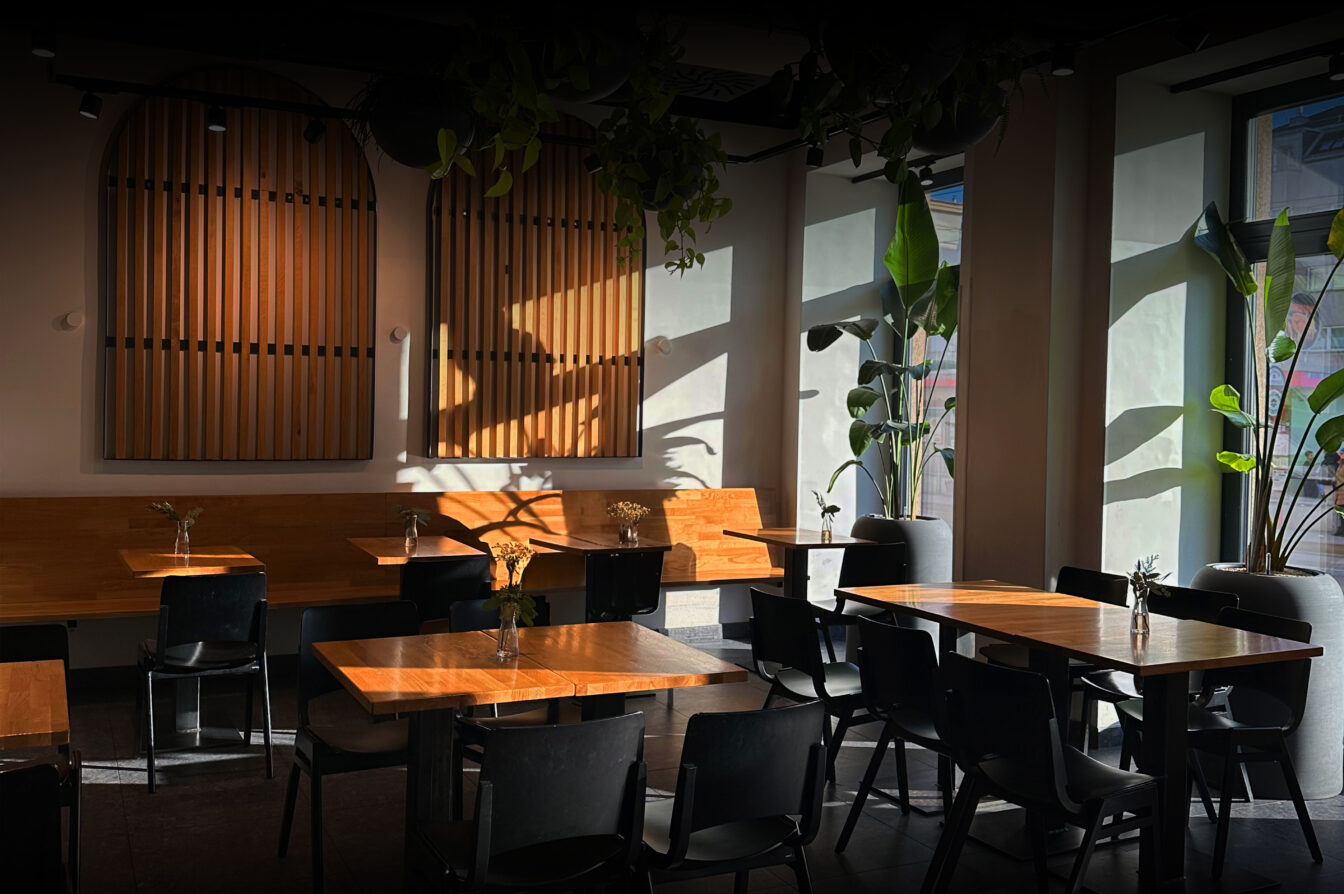 Interior view of GOTA Coffee Experts with tables and natural light: A café in the 15th district for Eurovision Song Contest visitors in Vienna