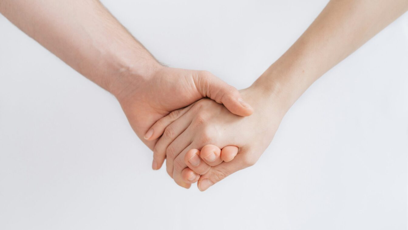 Zwei Personen halten sich an der Hand