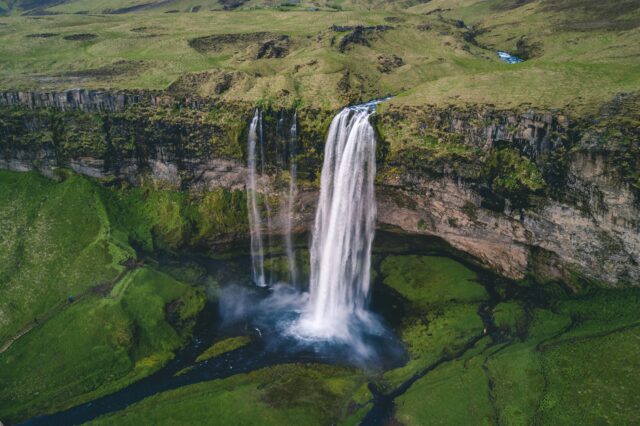 Grüne Wiesen in Island mit Wasserfall