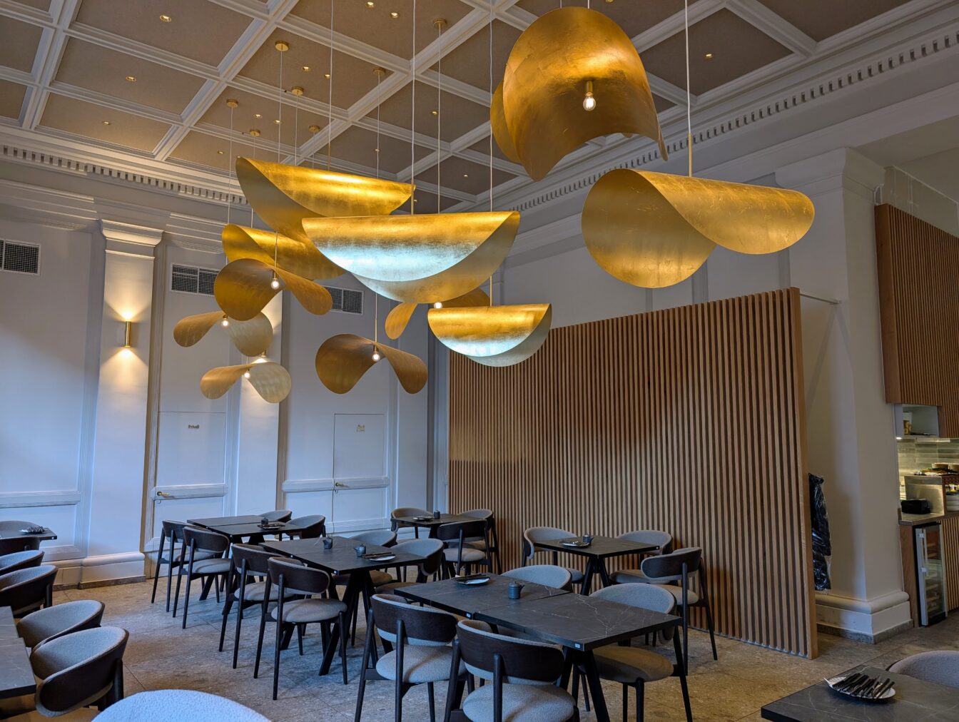 Tische, Sesseln und die markante Deckenbeleuchtung im Restaurant Nikkai in Wien