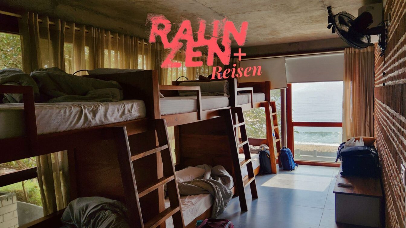 Mehrbettzimmer in einem Hostel mit Hochbetten aus Holz, Tageslicht durch große Fenster mit Meerblick, Vorhänge sorgen für Privatsphäre. Rucksäcke und Gepäck deuten auf reisende Gäste hin. An der Wand ist der Schriftzug ‚RauhnZEN + Reisen‘ eingeblendet – Symbol für digitales Arbeiten oder kreative Auszeit unterwegs