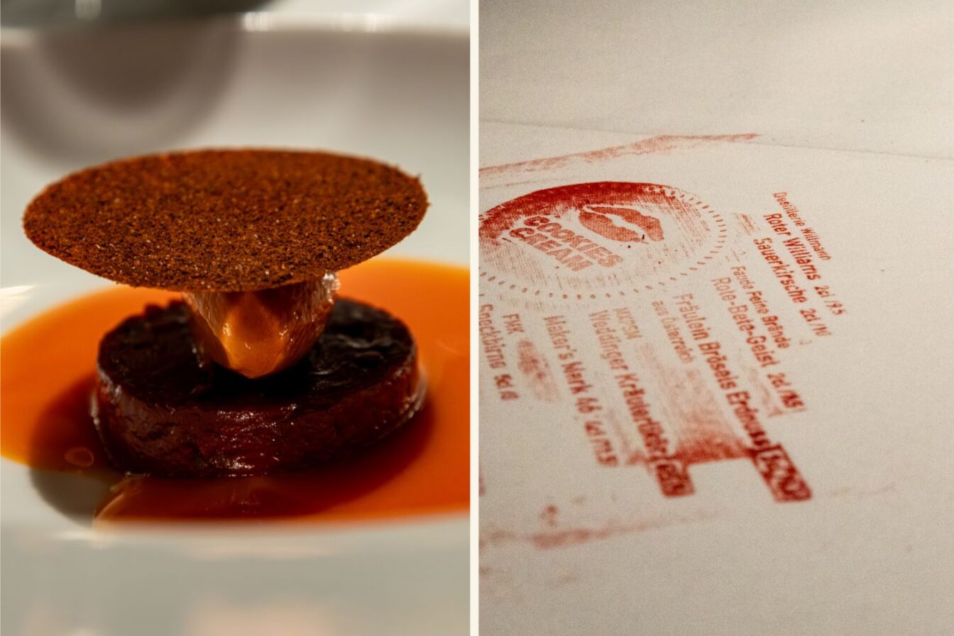 Links eine Nahaufnahme eines avantgardistisch angerichteten Gerichts: ein rundes Stück Gemüse oder Fleisch, darauf eine karamellisierte Komponente und ein dünner, kreisrunder Chip – alles in roter Sauce. Rechts ein in roter Tinte gestempeltes Branding von Cookies Cream mit Adresse und Logo auf weißer Tischdecke – wirkt wie ein kreativer „Signature Move“ des Lokals.
