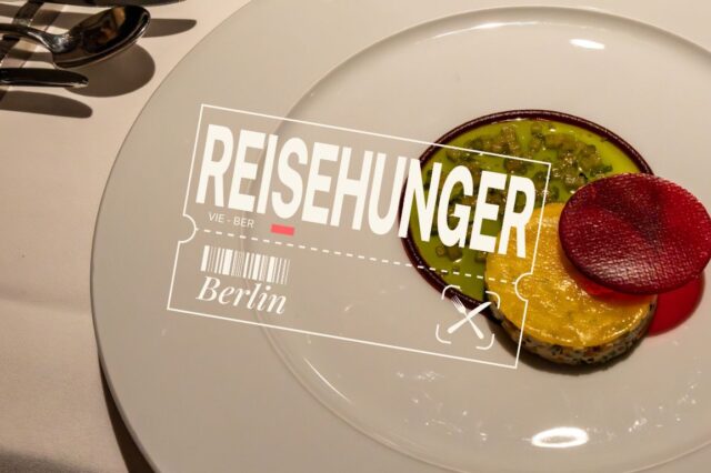 Ein edel angerichteter Teller mit einem kunstvollen veganen Gericht: grüne und gelbe Gemüsekomponenten, garniert mit einer runden, knallroten Scheibe – vermutlich Rote Bete – auf einem weißen Porzellanteller. Links im Bild glänzendes Besteck auf weißer Tischdecke. Darüber liegt ein grafisches Overlay mit dem Schriftzug „REISEHUNGER“, einem stilisierten Flugticket von Wien nach Berlin (VIE – BER), darunter die Wortmarke „Berlin“ und ein kleiner Flugzeug-Icon. Das Bild vermittelt kulinarische Reiselust mit Fokus auf Fine Dining in Berlin.