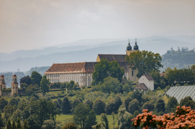 Historisches Kloster Stainz im Schilcherland in der Steiermark, eingebettet in grüne Hügel und Weinberge mit Blick auf die malerische Landschaft der Südweststeiermark.