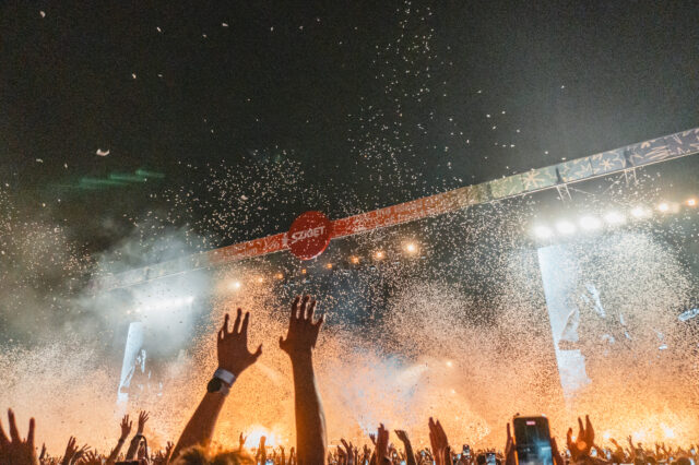 Eine hubelnde Menge vor einer großen, beleuchteten Bühne