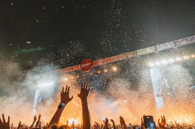 Eine hubelnde Menge vor einer großen, beleuchteten Bühne