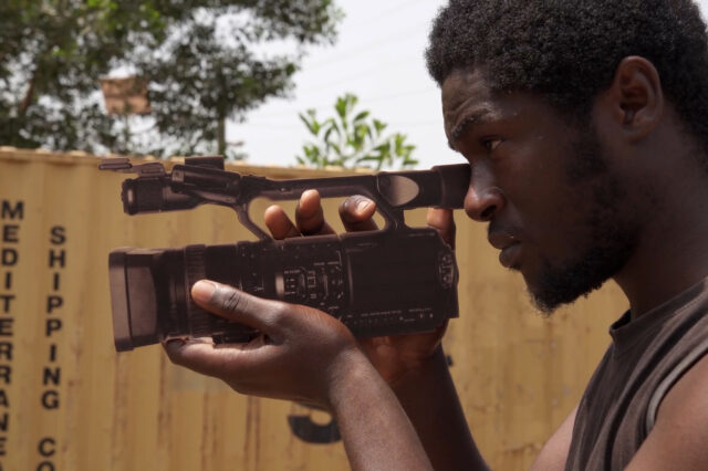 Ein Mann mit Filmkamera in der Hand.