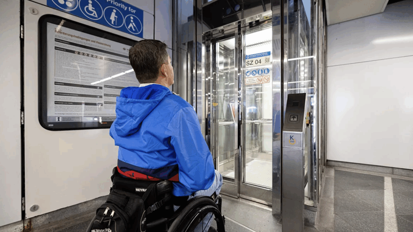 Ein Mann im Rollstuhl vor einem Aufzug in einer U-Bahn-Station in Wien.