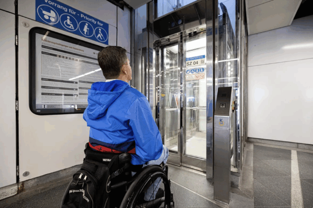 Ein Mann im Rollstuhl vor einem Aufzug in einer U-Bahn-Station in Wien.