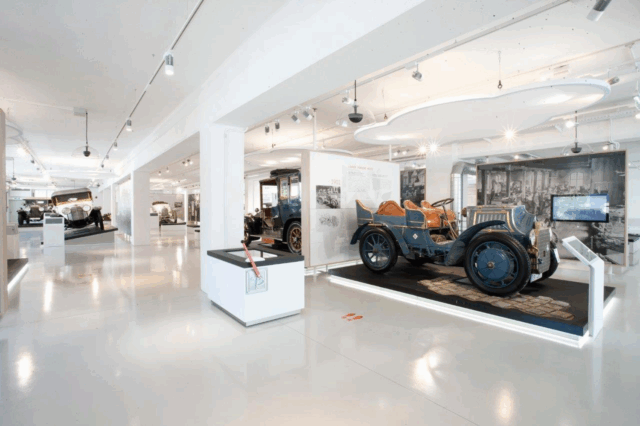 Innenansicht des fahr(T)raum Museums mit historischen Automobilen, darunter der Lohner-Porsche Mixte von 1901, ausgestellt in moderner, heller Umgebung – ideal für Technik- und Autogeschichte-Enthusiasten.