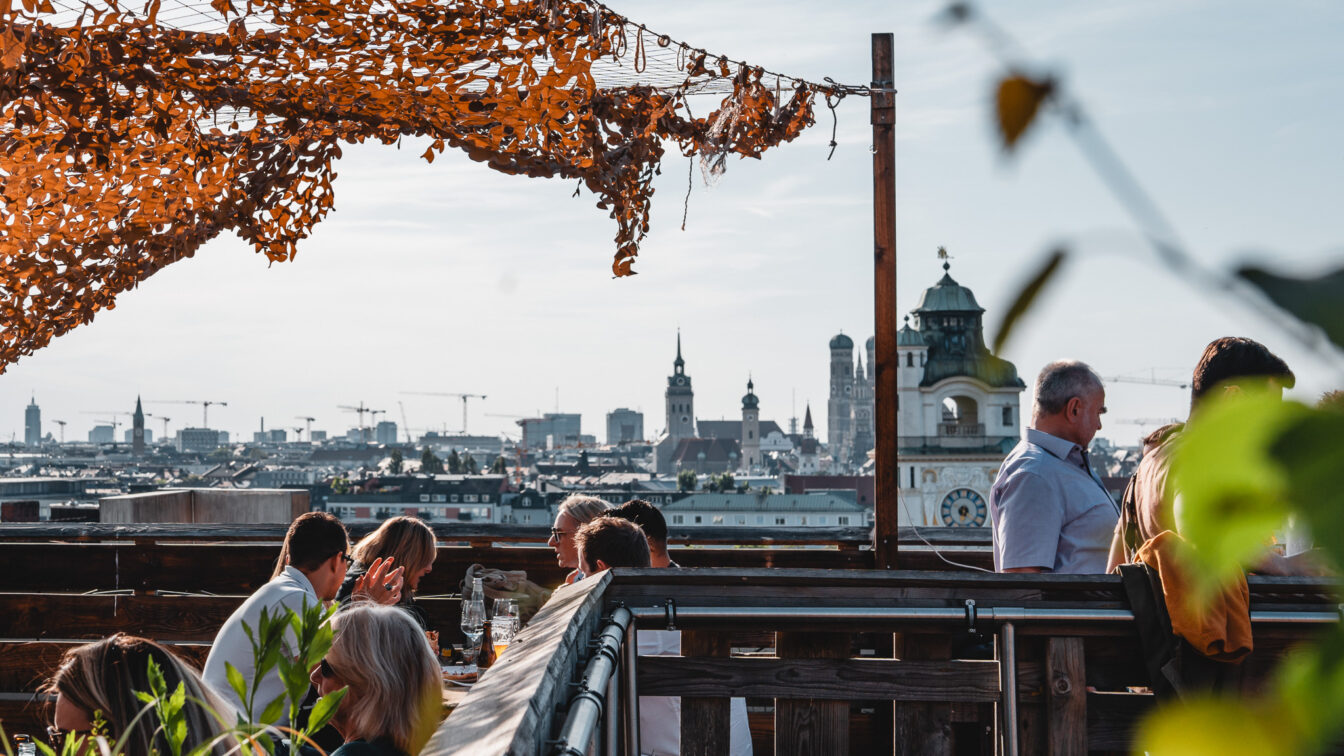 Die Dachgarten Rooftopbar in München auf dem Gasteig mit Blick auf die städtische Skyline.