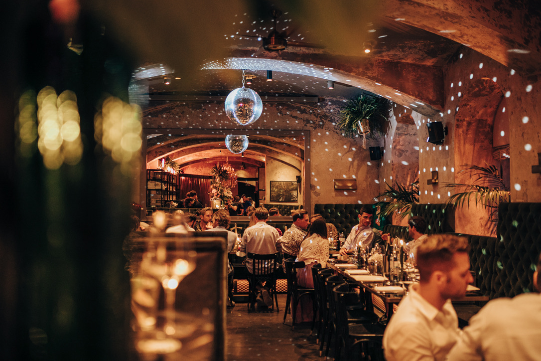 Blick in das gut besetzte Restaurant Thell in Wien bei Abendstimmung