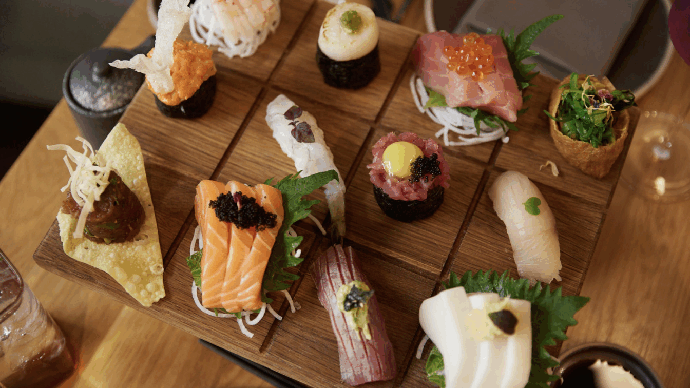 Eine Holzplatte mit verschiedenen Sushi-Kreationen.