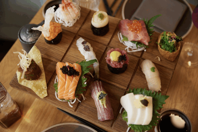 Eine Holzplatte mit verschiedenen Sushi-Kreationen.