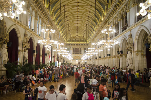 Großer Festsaal im Wiener Rathaus beim Kinderlesefest, gefüllt mit zahlreichen Besucherinnen, bunten Ständen und festlicher Beleuchtung – Veranstaltung für Familien und Kinder in Wien