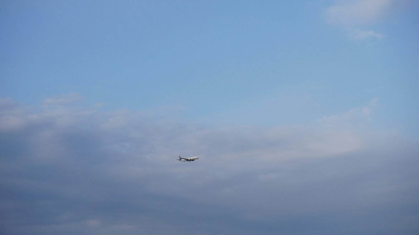 Flugzeug einer Billigfluglinie beim Landeanflug vor bewölktem Himmel – Symbolbild für günstiges Fliegen und versteckte Zusatzkosten bei Low-Cost-Airlines.