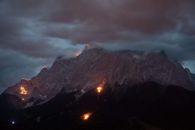 Spektakuläres Sonnwendfeuer in der Tiroler Zugspitz Arena – leuchtende Bergfeuer und mystische Stimmung rund um die Zugspitze bei Nacht, traditionsreiches Schauspiel in den Alpen.