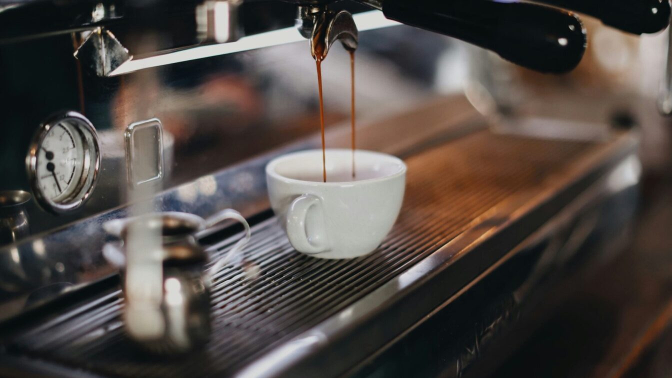 Eine Tasse Espresso, die gerade in der Siebträgermaschine zubereitet wird.