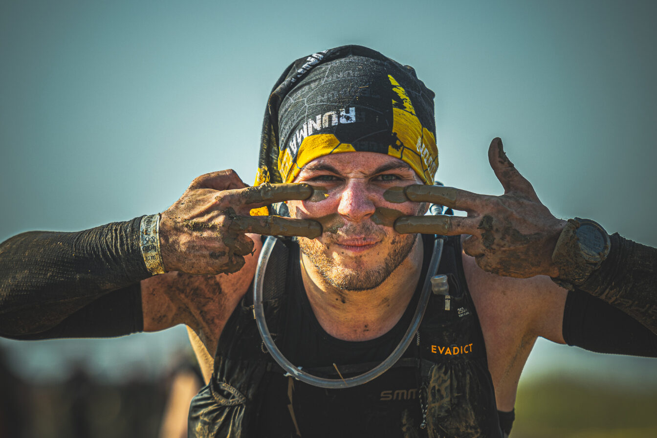 ein von Anstrengungen gezeichneter Wettkämpfer beim Hindernislauf Runmageddon X