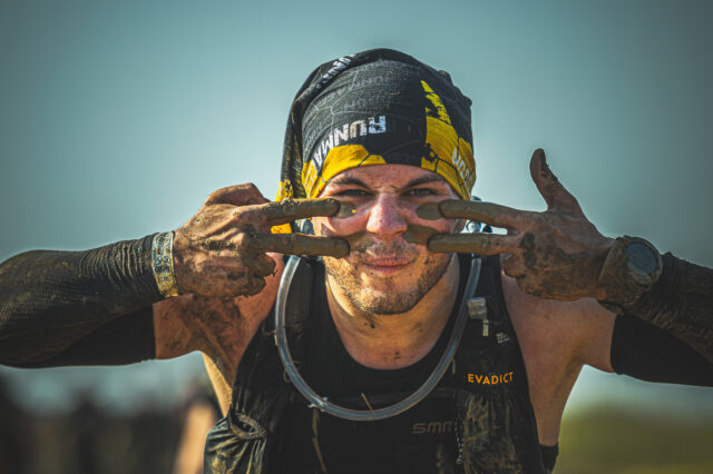 ein von Anstrengungen gezeichneter Wettkämpfer beim Hindernislauf Runmageddon X