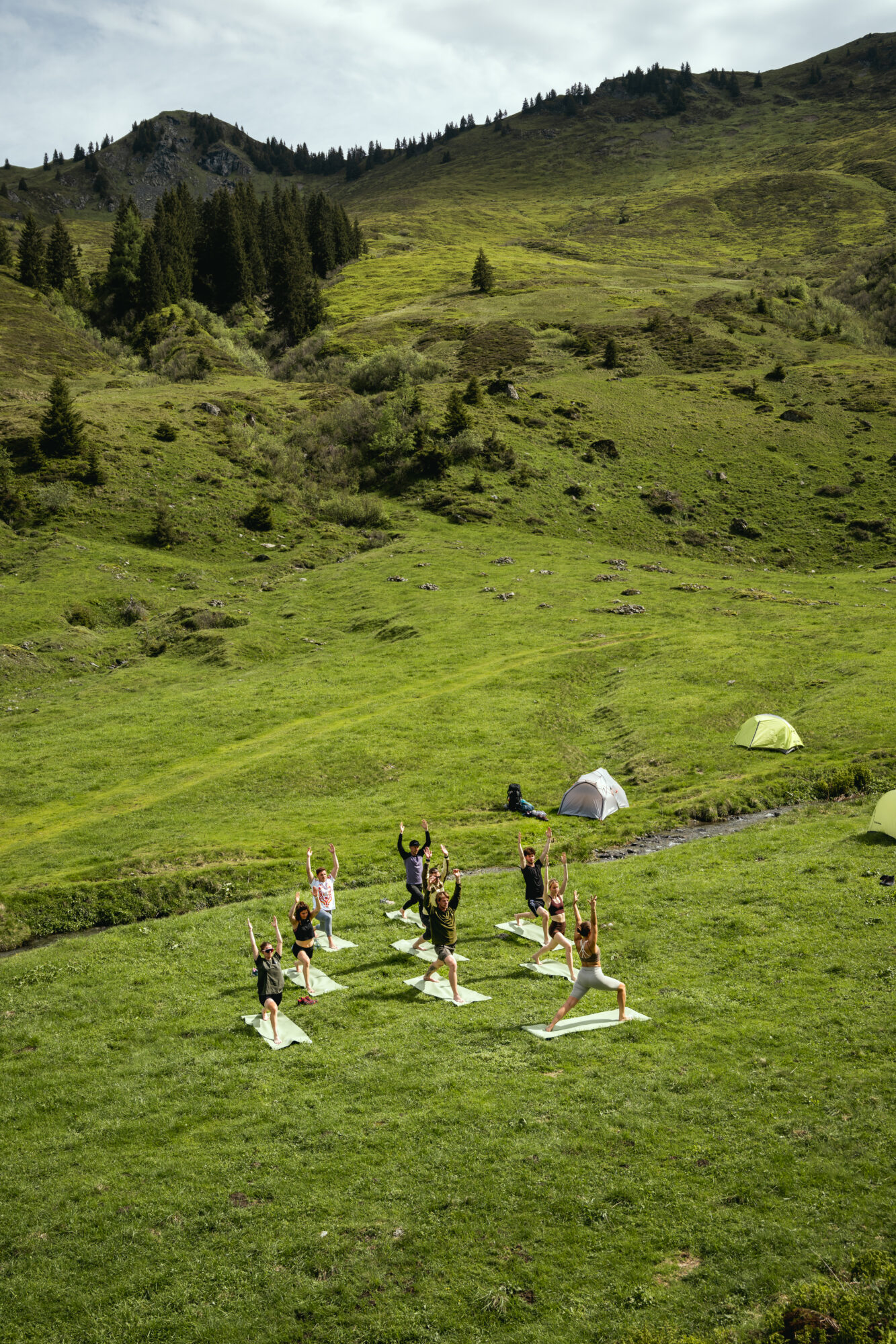 Mehrere Menschen machen Yoga in den Bergen