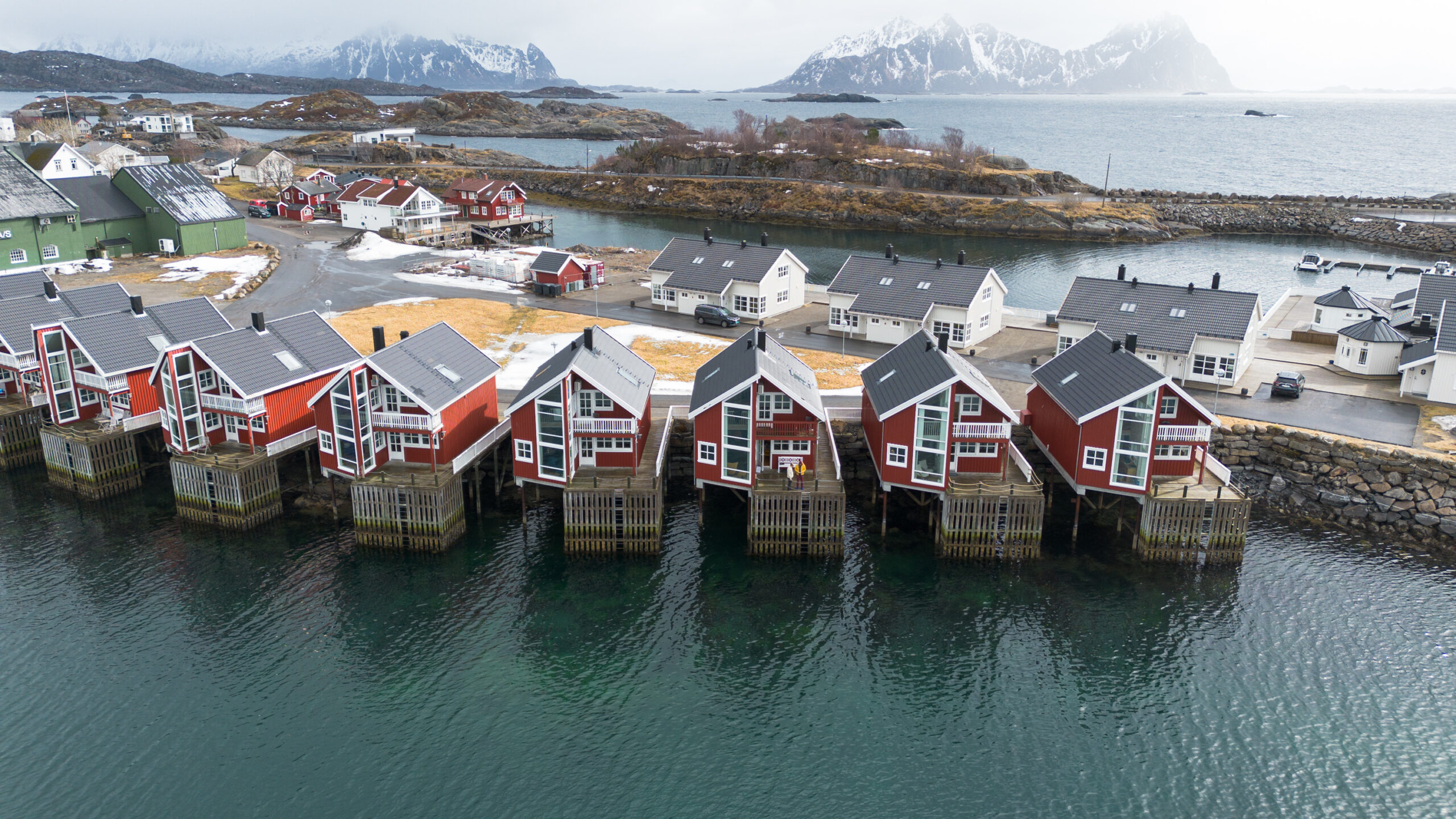 Mehrere rote Hütten über dem Meer in Norwegen