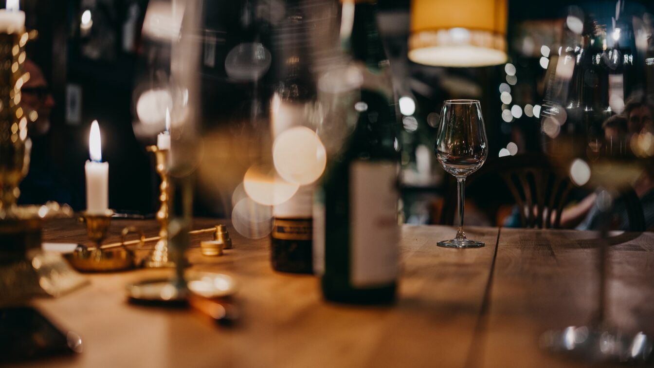 Holztisch mit gläsern und einer Flasche Rotwein