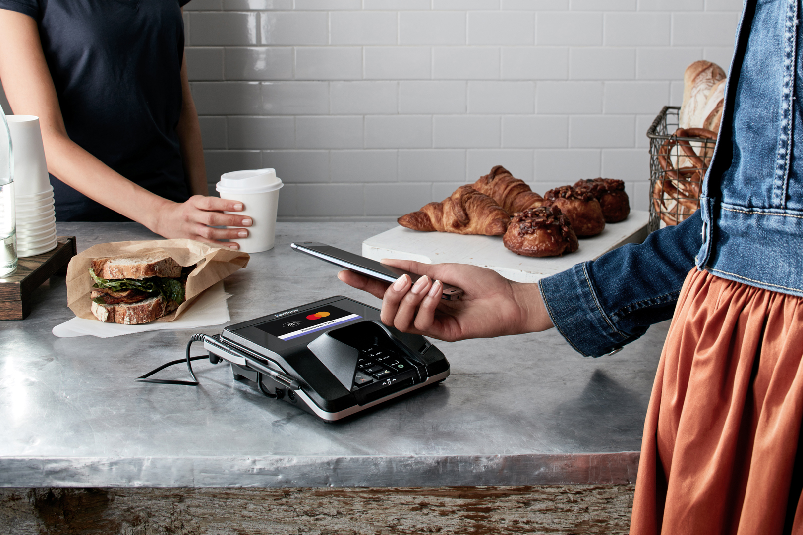 Person zahlt im Café mit der Karte