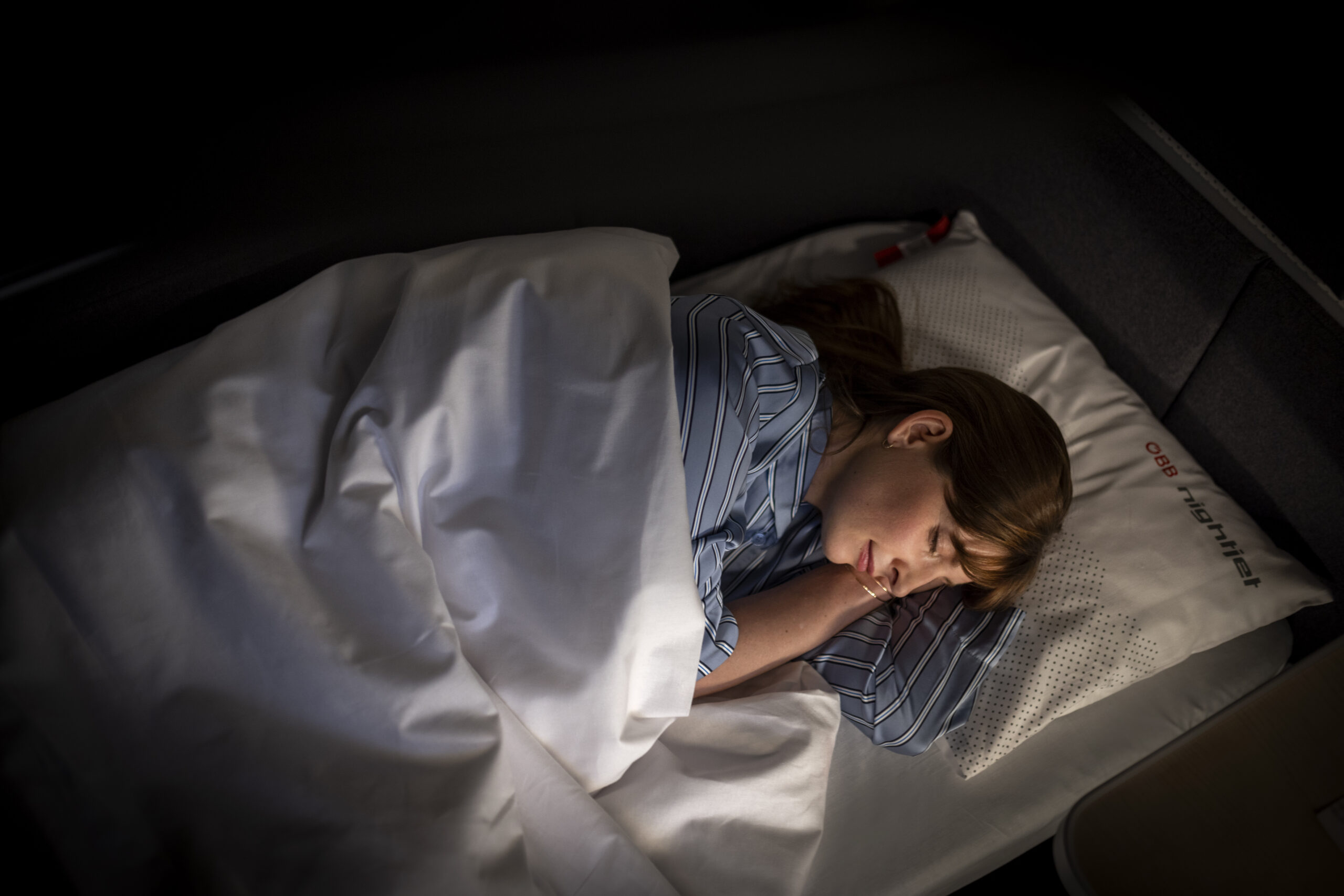 Frau schläft im Nachtzug