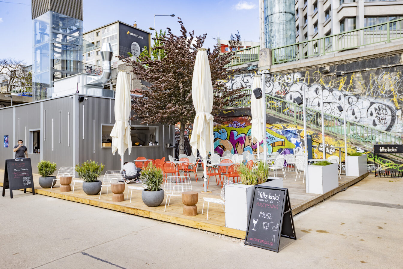 Tische und Sessel im Außenbereich beim Restaurant Muse am Wiener Donaukanal