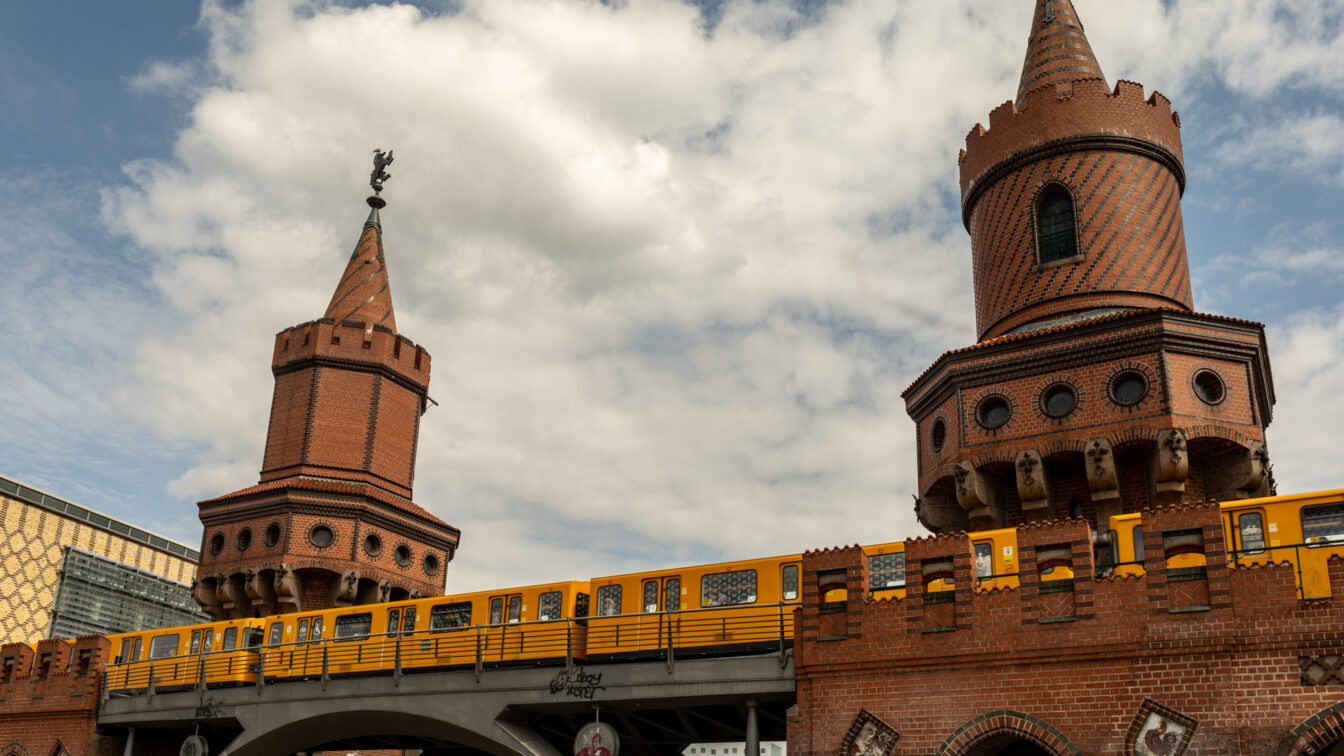 Gelbe Berliner U-Bahn fährt über die historische Oberbaumbrücke im Stadtteil Friedrichshain, Wahrzeichen und Sehenswürdigkeit in Berlin.