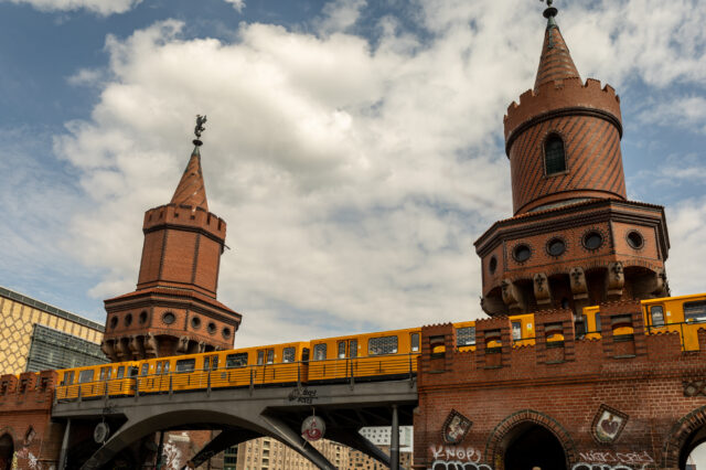 Gelbe Berliner U-Bahn fährt über die historische Oberbaumbrücke im Stadtteil Friedrichshain, Wahrzeichen und Sehenswürdigkeit in Berlin.